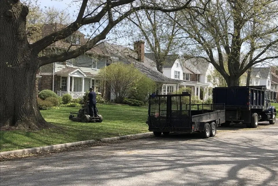 Worker making the first spring cut on a stand-on mower