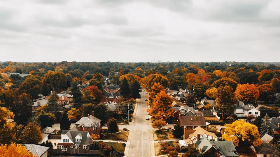 Aerial view of a tree-filled Midwest neighborhood in fall